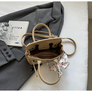 Detailansicht der khakifarbenen Ledertasche mit Seidenschal und gestreiftem Innenfutter