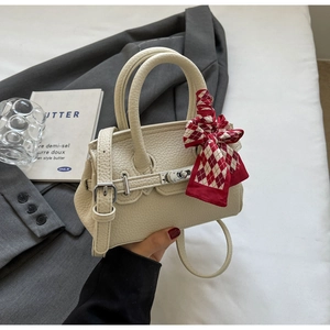 Detail der beigen Mini-Handtasche aus genarbtem Leder mit Seidenschal und Silberverschluss