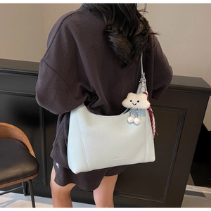 Detail of light blue lychee texture tote bag with cloud charm and silk scarf decoration