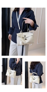 Detail of cream white leather handbag featuring silver twist lock and smooth texture