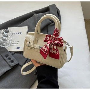 Detailansicht der cremefarbenen Mini-Handtasche aus strukturiertem Leder mit Seidenschal