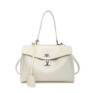 Detail of off-white leather handbag featuring silver twist-lock and elegant tag charm