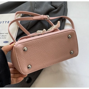 Detailansicht der rosa Ledertasche mit vier silbernen schützenden Metallfüßen am Boden