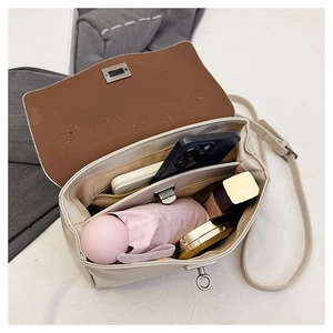 Interior view showing large capacity for phone, umbrella and makeup in beige handbag