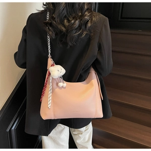 Detail of pink pebbled leather tote with silver chain and white cloud pendant charm