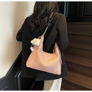 Rear view of a light pink pebbled leather hobo bag with silver chain and plush cloud charm