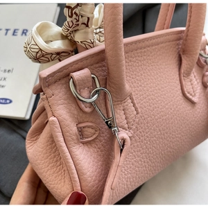 Detail der rosa Handtasche aus Leder mit dekorativem Seidenschal und silberner Metallschnalle
