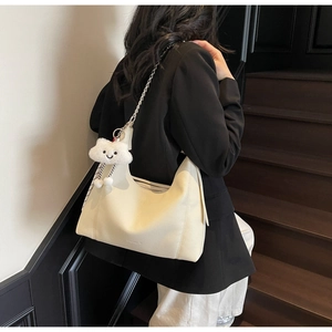 Detail of creamy white pebble leather hobo bag with gold chain strap and cloud charm