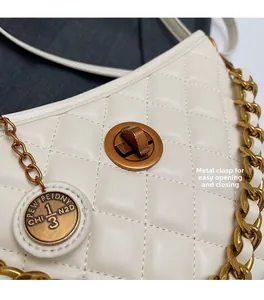 Macro detail of the vintage bronze twist lock and quilted leather on the crossbody bag