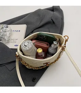 Top view of spacious cream quilted bucket bag interior showing phone and wallet