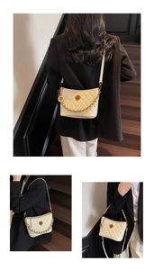 Detail of cream quilted bucket bag with gold chain strap and elegant metallic accent
