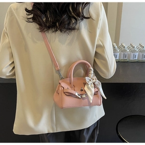 Detail der rosa Mini-Handtasche mit Lychee-Maserung, Silberschnalle und Seidenschal