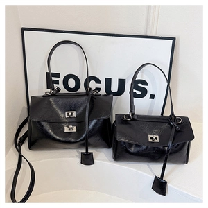 Comparison of large and small black crinkled leather handbags with silver twist locks