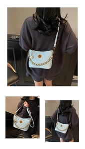 Close-up of quilted light blue crossbody bag with gold chain and metal lock detail