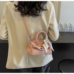Detailansicht der rosa Mini-Handtasche aus Leder mit Seidenschal und klassischem Metallschloss