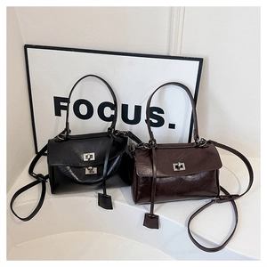 Detail of minimalist leather crossbody bags in black and coffee with metal twist locks