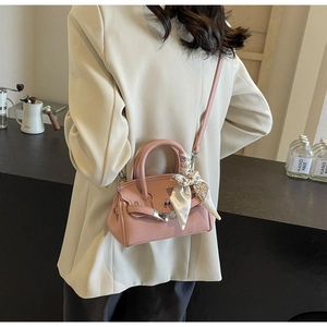 Detail einer rosa Handtasche aus Leder mit gebundenem Seidentuch und elegantem Griff
