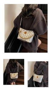 Close-up of silver quilted crossbody bag with gold chain strap and turn-lock detail