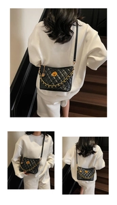 Detailed close-up of black quilted bag with gold chain strap and metal rotary lock