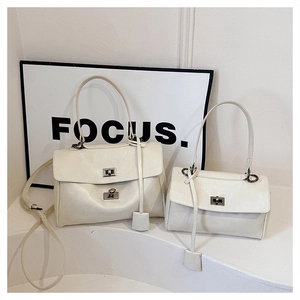 Two cream minimalist handbags in different sizes with silver metallic twist locks