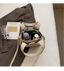 Spacious interior of lychee pattern bucket bag holding a water bottle and umbrella