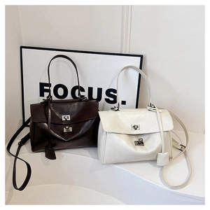 Detail of vintage oil wax leather handbags in coffee and beige with double buckle design