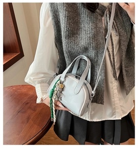 Detail of light blue crossbody bag featuring white ZIANDI lettering and bear charm