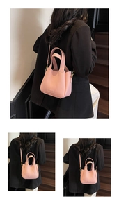 Close-up of pink litchi leather bucket bag showing dual handles and detachable strap