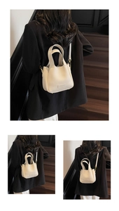 Chic beige bucket bag with litchi texture shown in elegant styling on stairs