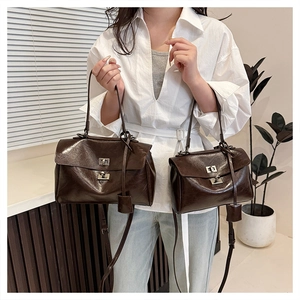 Size comparison of dark brown glossy leather handbags with metal turn-lock closures