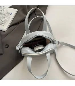 Interior view of small square bag showing spacious capacity for wallet and cosmetics