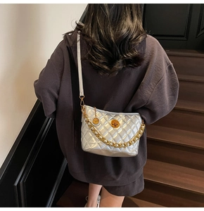 Silver quilted crossbody bag with gold chain detail and turn-lock shown on shoulder