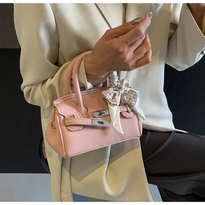 Detail der rosa Mini-Handtasche aus Litchi-Leder mit seidigem Tuch am Tragegriff