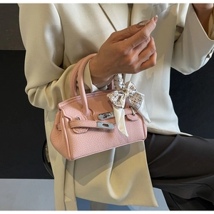 Detailaufnahme einer rosa Mini-Handtasche aus genarbtem Leder mit Seidenschal am Griff