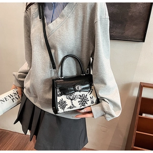Detail view of mini Kelly bag with nature-inspired print and metal turn-lock closure