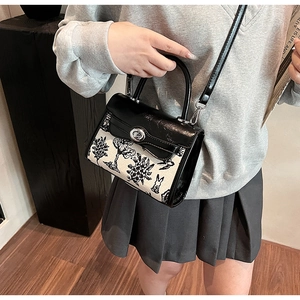 Detail of a retro printed floral handbag featuring a vintage rabbit pattern and metal lock