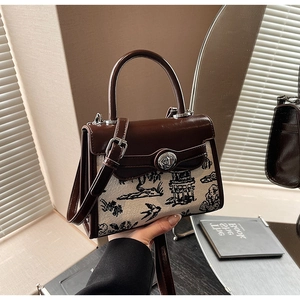 Detail view of a vintage Chinese style handbag with landscape print and silver twist lock