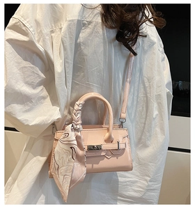 Detail der hellrosa Mini-Handtasche mit Seidentuch am Griff und silberner Hardware