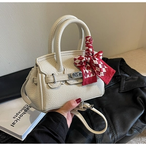 Detailansicht der weißen Lederhandtasche mit dekorativem Seidenschal am Griff für Damen
