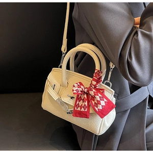 Detail der cremeweißen Handtasche aus Leder mit Seidentuch und silbernem Schloss