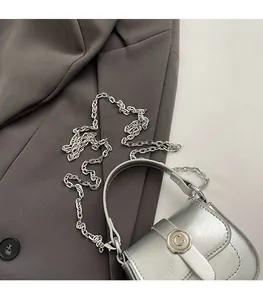Detail view of silver mini square bag with metallic leather texture and chain strap