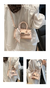 Detailansicht der hellrosa Handtasche mit dekorativem Seidenschal und Metallschnalle