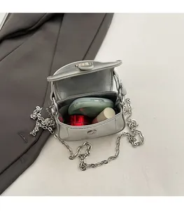 Close-up of silver mini chain bag interior showing storage for lipstick and powder