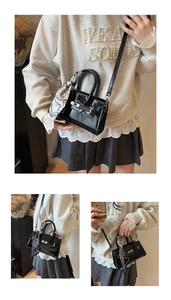 Detailsicht der schwarzen Lackledertasche mit Silberverschluss und Seidenschal
