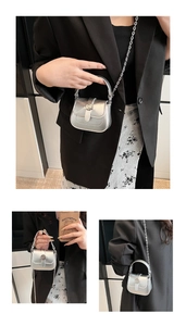 Close-up of mini silver metallic crossbody bag with chain strap and twist lock detail