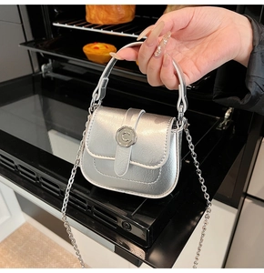 Detailed shot of silver mini crossbody bag with metal C-buckle and fine chain strap
