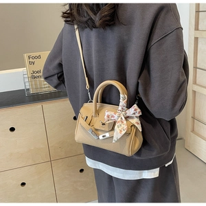 Detail der Handtasche aus genarbtem Leder mit Seidenschal-Griff und Silberverschluss