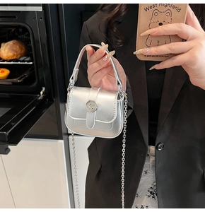 Detail of silver mini crossbody bag with metal C-buckle and elegant chain strap