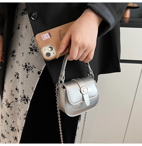 Close-up of a mini silver metallic bag with round C-letter buckle and chain strap