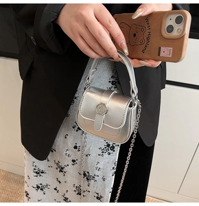 Detail of silver mini saddle bag with metal C-buckle and detachable chain strap